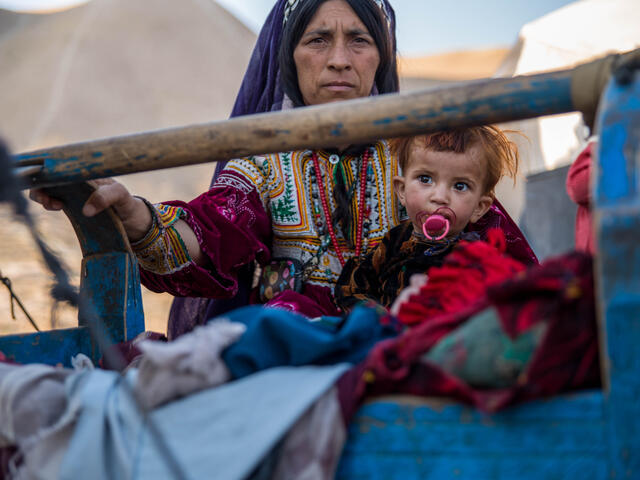 Kvinna på flykt med sitt barn i Afghnistan