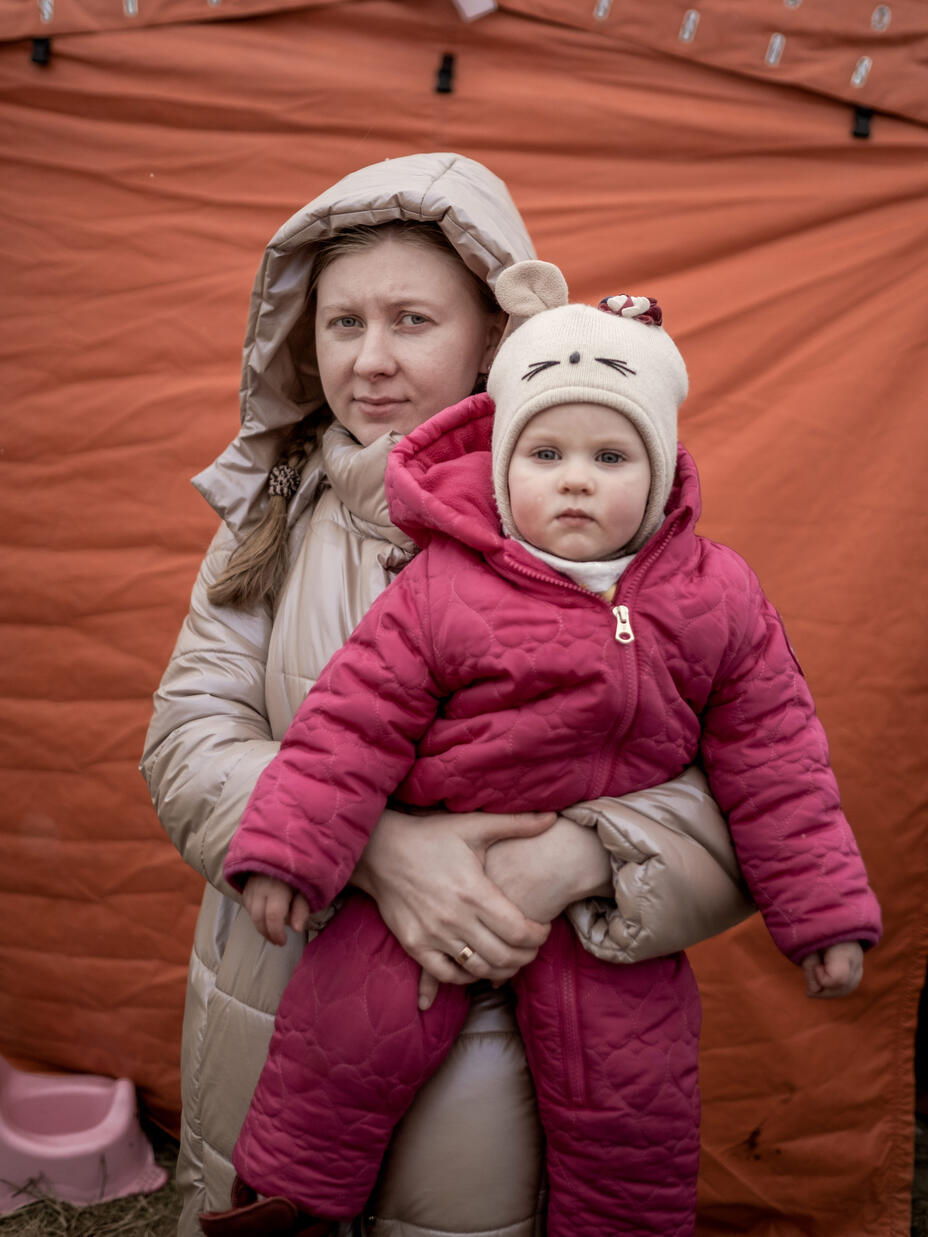 Iryna håller sitt barn i famnen och båda har vinterkläder på sig