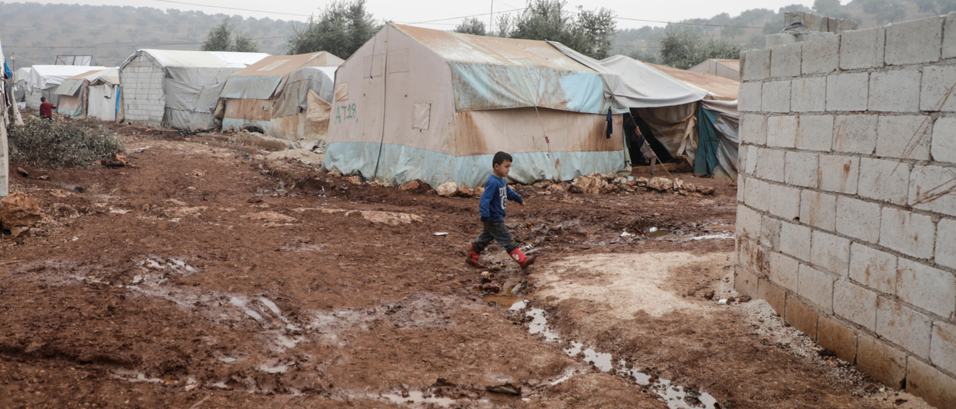 Pojke går genom ett läger i Syrien