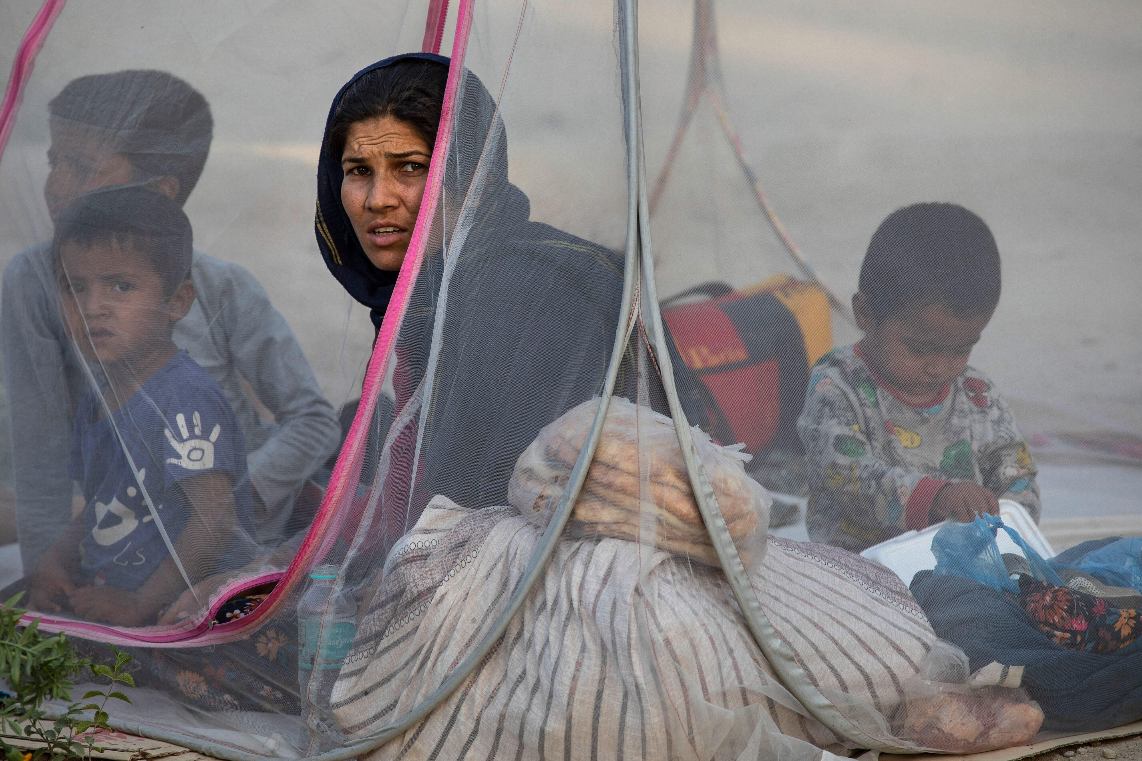 Familj som är på flykt i Afghanistan sitter i sitt tält 
