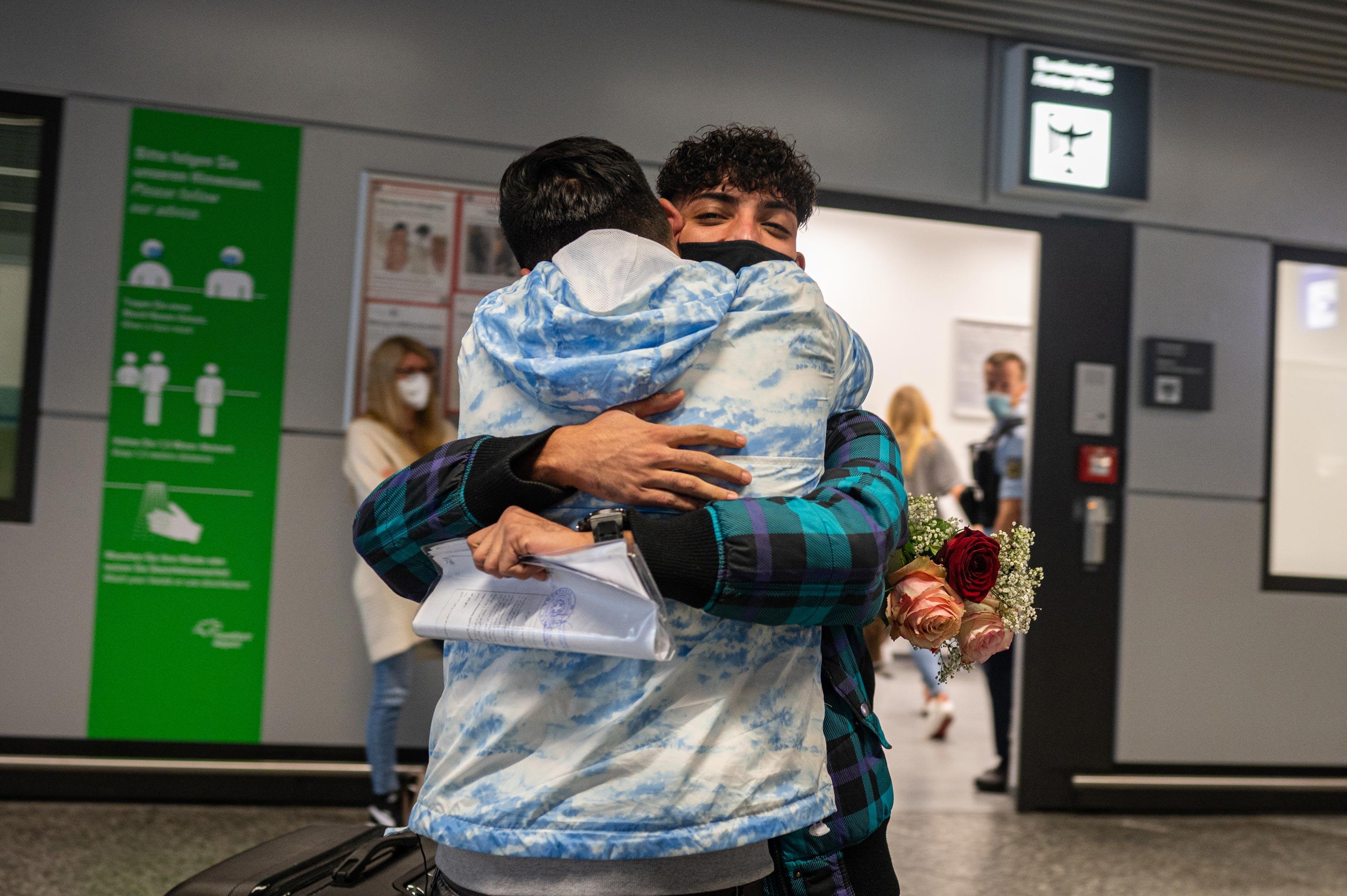 Ali och Mehdi kramar om varandra på flygplatsen