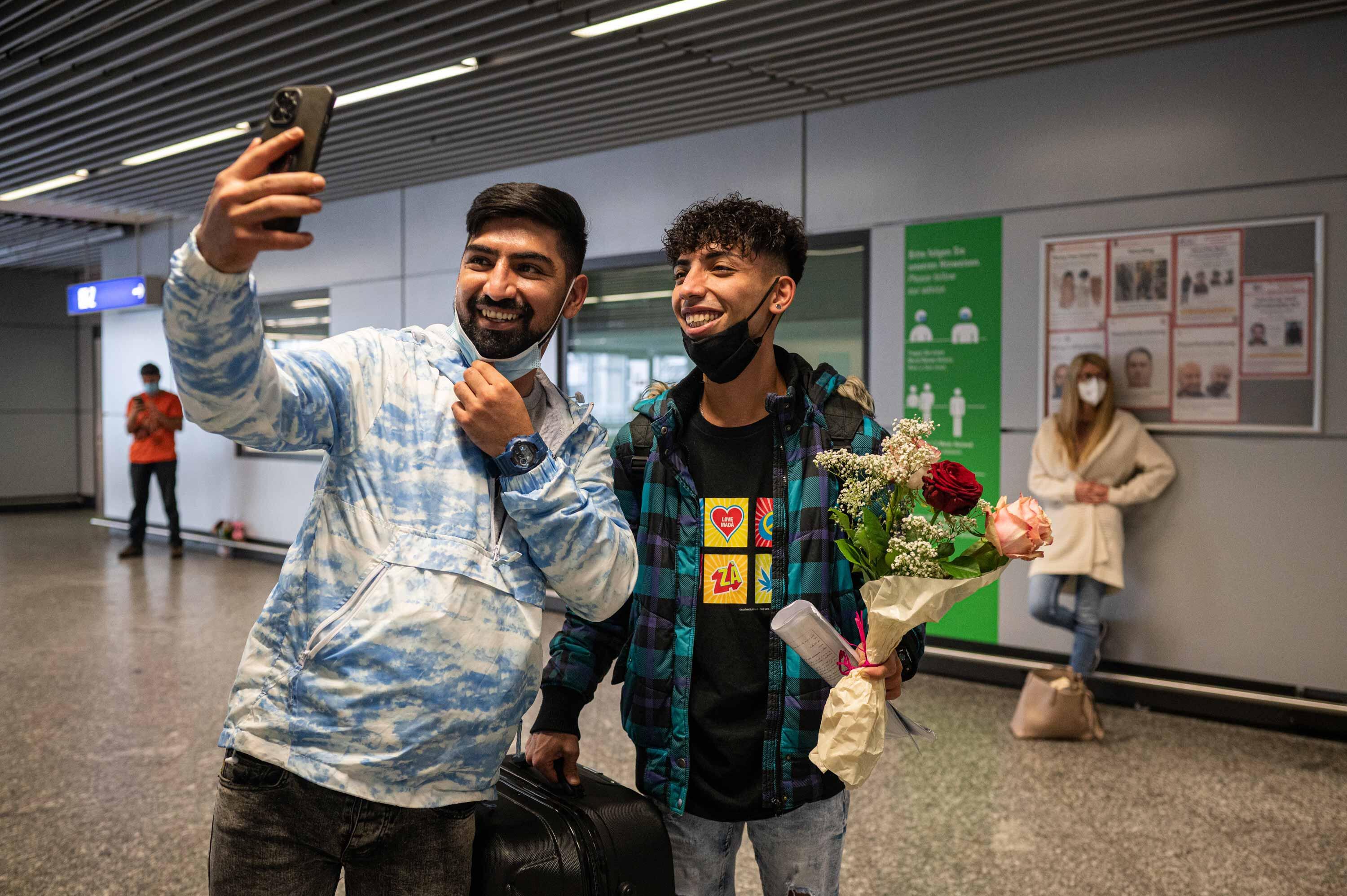 Ali und Mehdi machen ein Selfie am Flughafen.