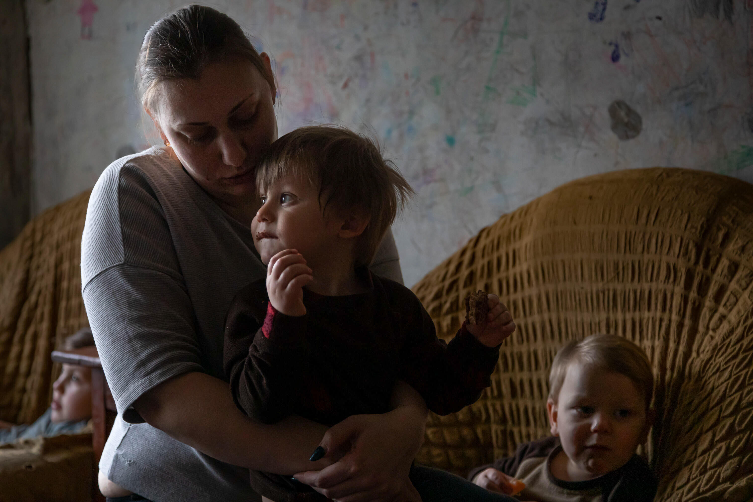 En mamma sitter och håller om sitt barn i Ukraina