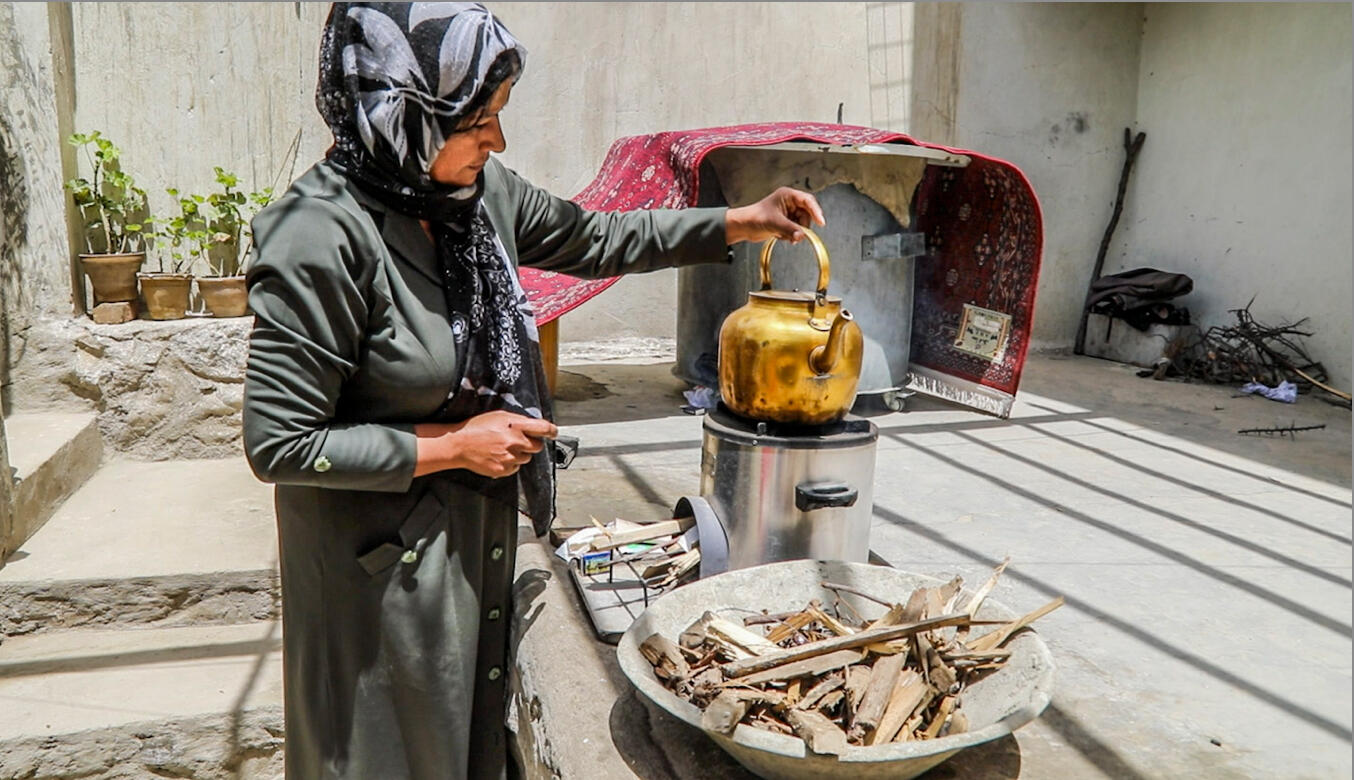 En kvinna använder ett stormkök i Afghanistan