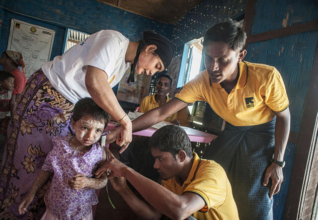 Sjukvårdare undersöker ett barn i Myanmar.