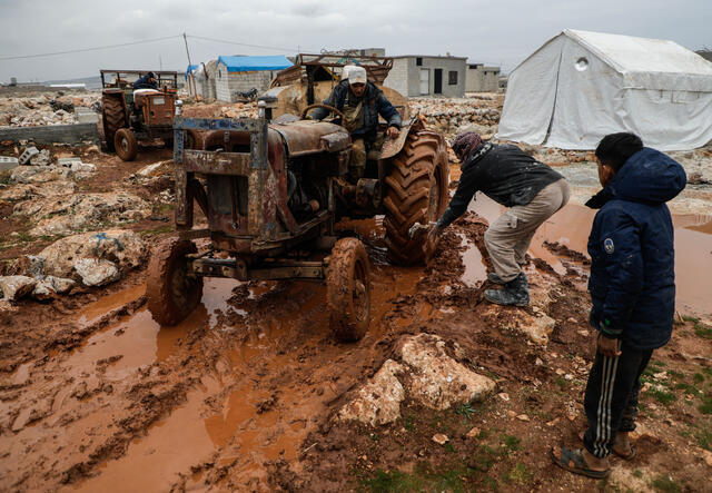 Traktor har fastnas i lervälling i ett flyktingläger i Idlib
