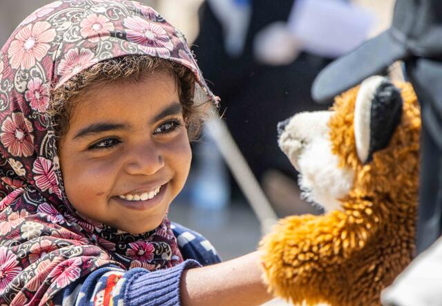 En flicka leker med handdocka som ser ut som en räv i Jemen