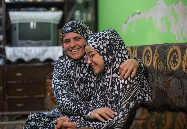 Mamma och dotter skrattar tillsammans i Syrien