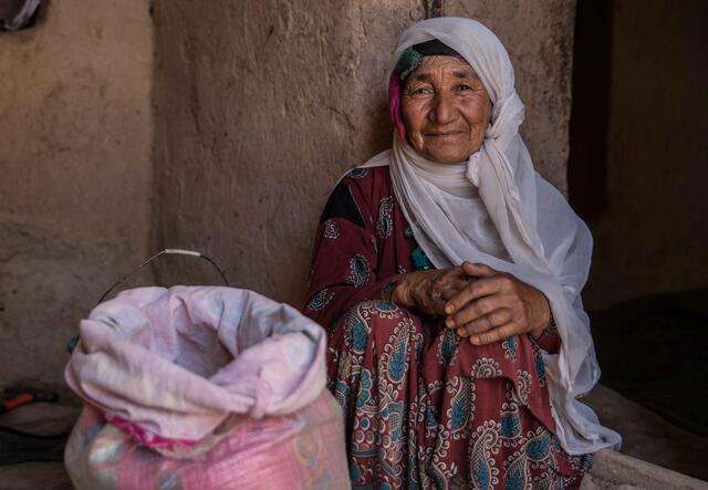 Fatima sitter bredvid en säck med spannmål i Afghanistan.