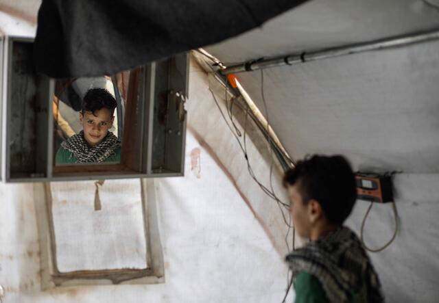 10-årige Omar tittar sig i spegeln i sitt tält i Syrien