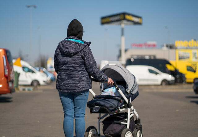Helen går med sin bebis på en gata efter att ha flytt Ukraina