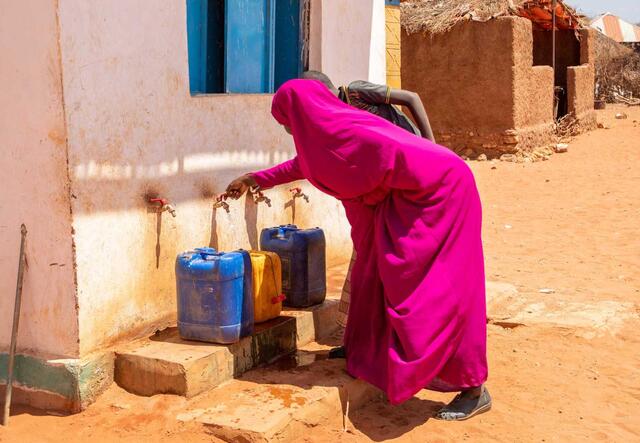 En kvinna hämtar vatten vid en brunn i Somalia