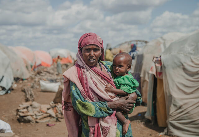 Somalia: en mamma håller i sitt barn på ett flyktingläger. 