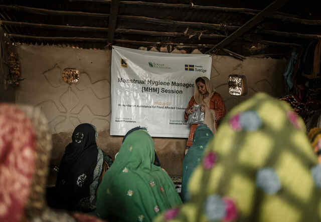 En kvinna föreläser om hygien för en grupp andra kvinnor utanför Sanghur, Pakistan.