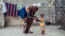 Naima och hennes barn Hadi övar på att gå utanför deras hus i Nigeria