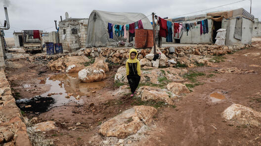 En pojke går omkring i ett flyktingläger i Idlib Syrien