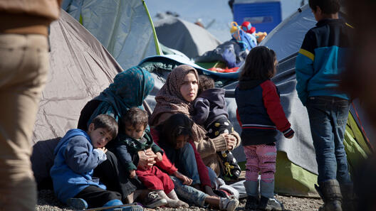 En barnfamilj sitter i ett flyktingläger
