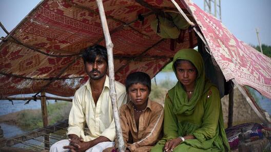 En familj från Sindh-provinsen i Pakistan, en av de regioner som drabbats hårdast av översvämningar, väntar på hjälp under ett tillfälligt skydd.