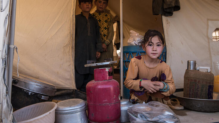 Barn sitter i sitt hem i Afghanistan och tittar in i kameran