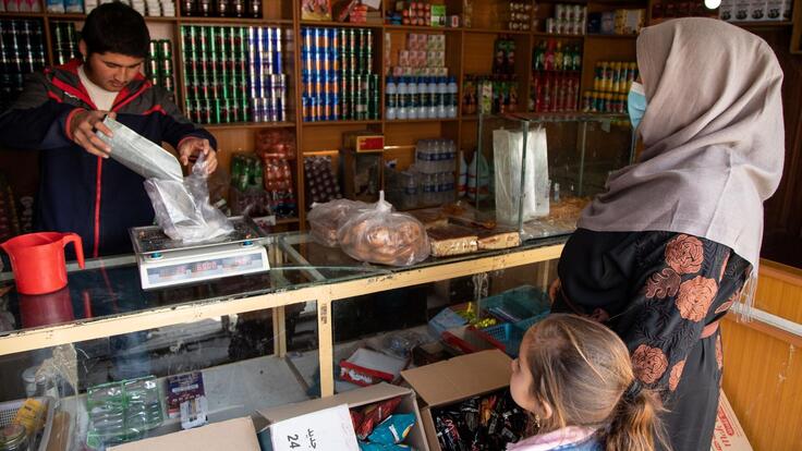 En mamma med barn handlar i en affär i Afghanistan
